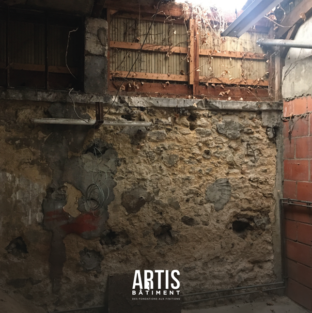 Mur en pierre brut avec ouverture existante avant rénovation intérieure et travaux de plâtrerie.