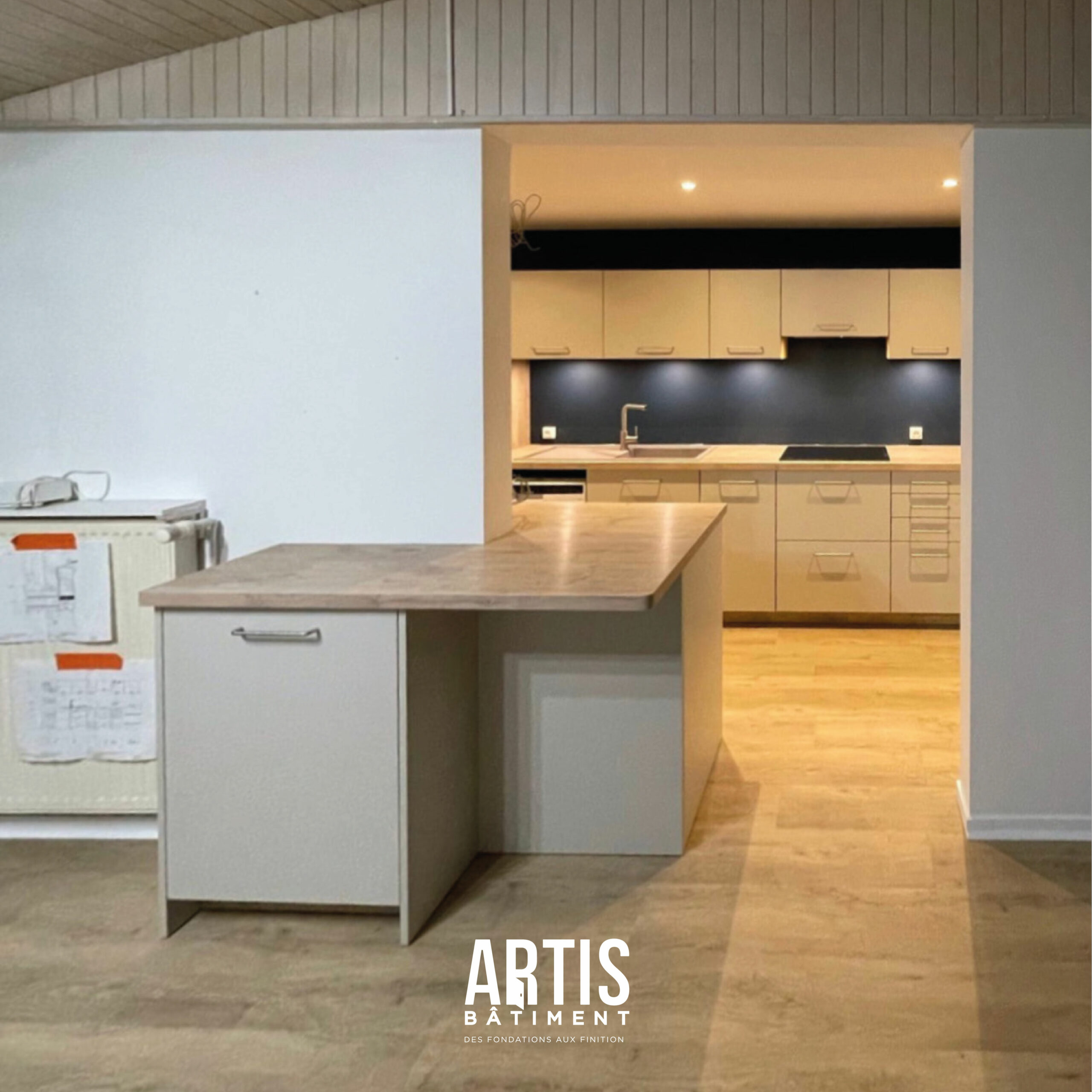 Cuisine ouverte moderne avec îlot central après rénovation intérieure.