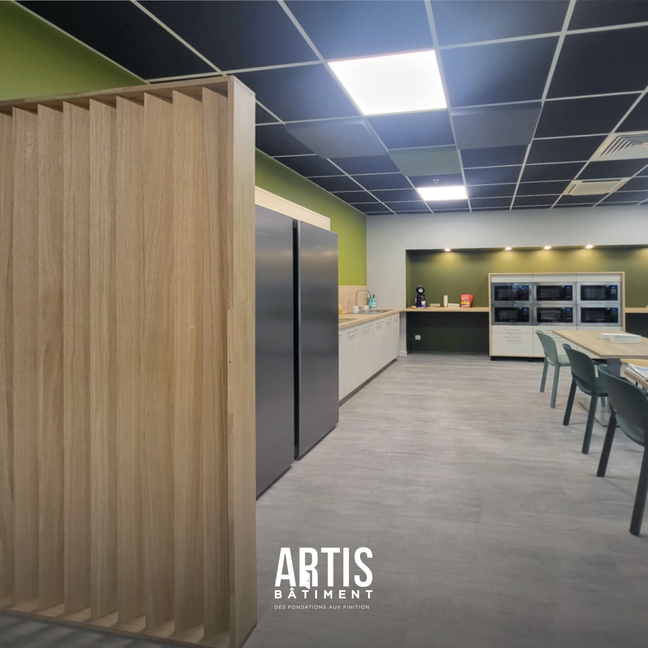 Aménagement d’une cuisine moderne dans une salle de pause d’entreprise avec réfrigérateurs et plan de travail.