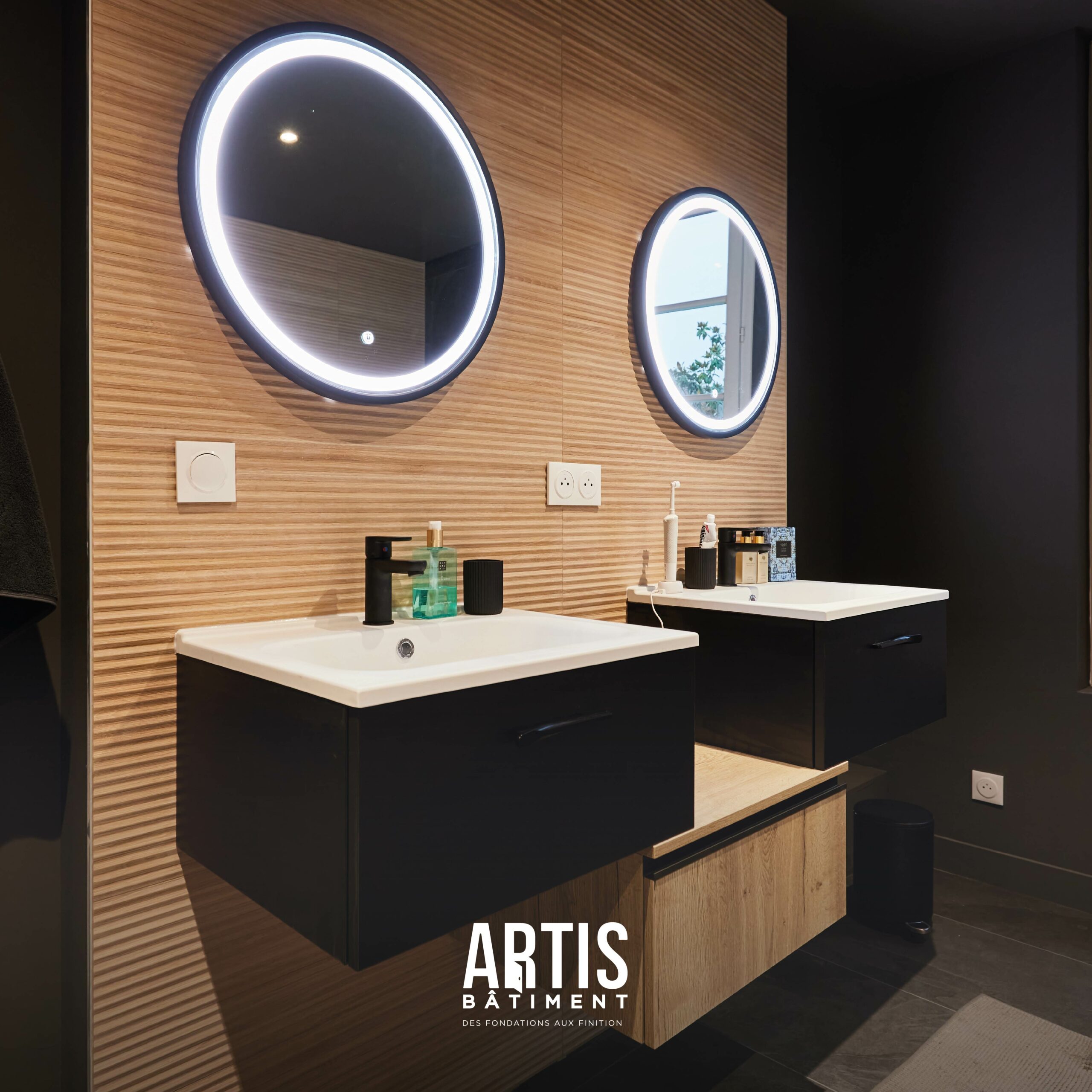 Meuble double vasque moderne avec miroirs LED dans salle de bain rénovée.
