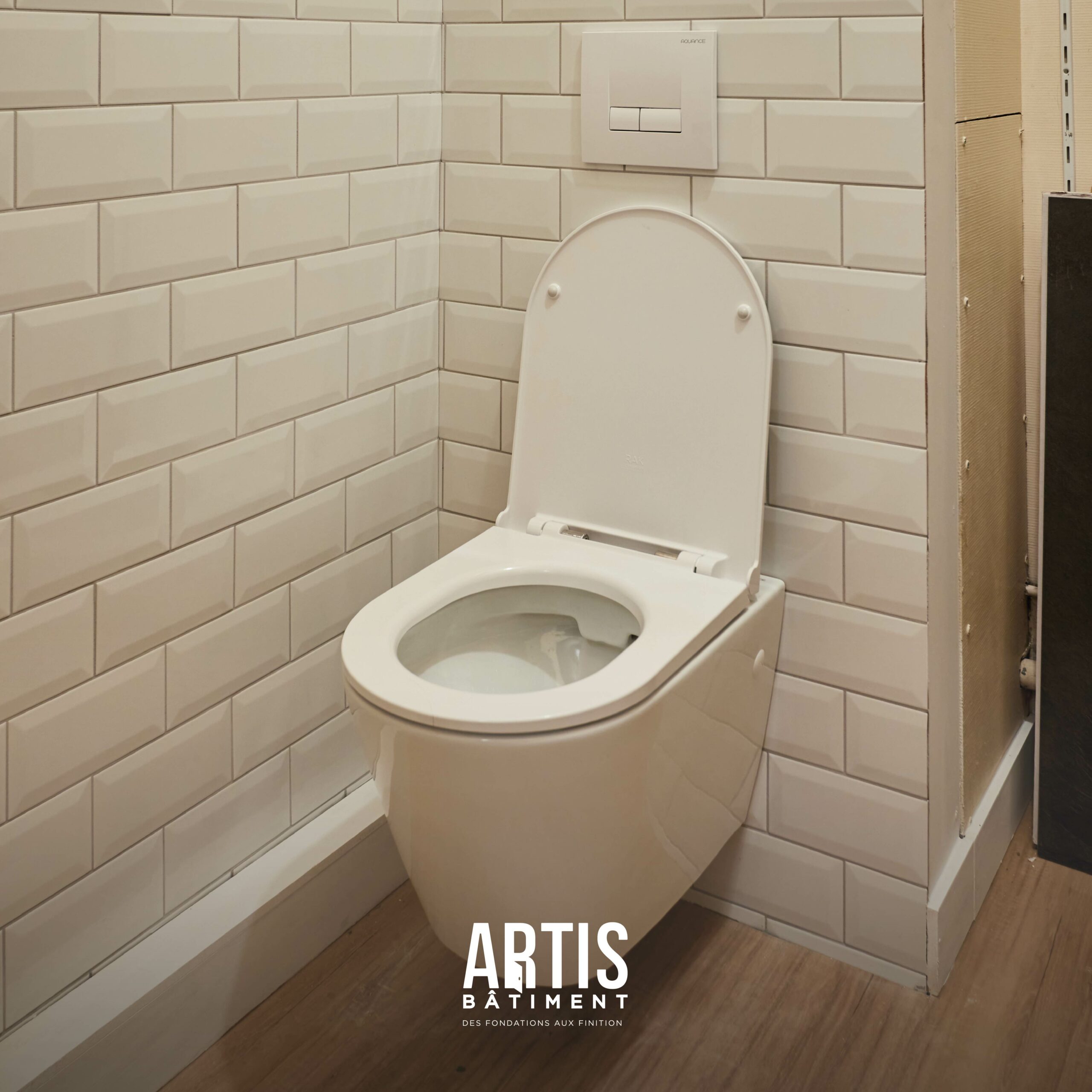 WC suspendu avec carrelage métro blanc après rénovation des toilettes.