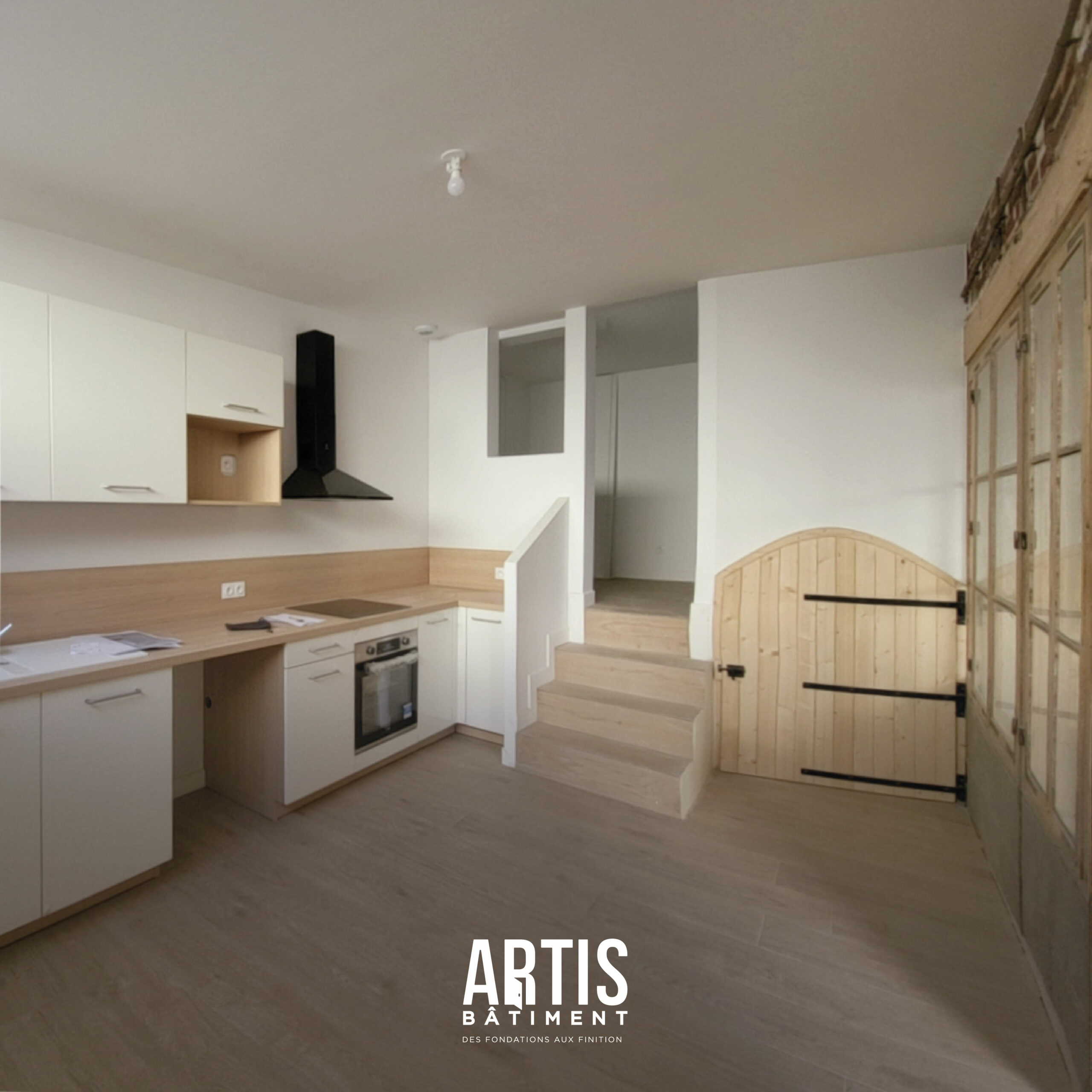 Cuisine moderne blanche et bois avec hotte noire et implantation en angle.