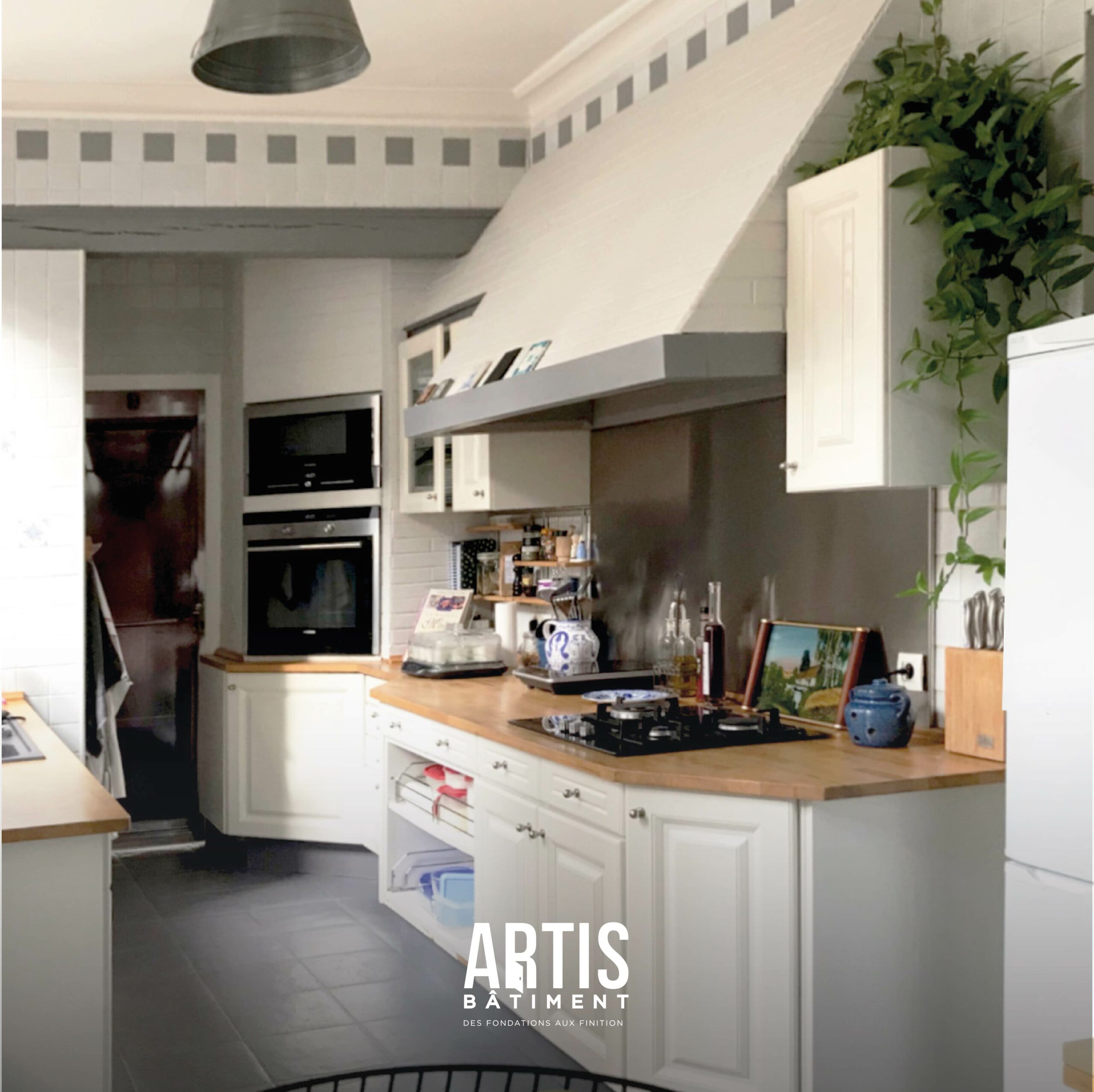 Ancienne cuisine avant travaux avec meubles blancs et plan de travail bois avant rénovation complète.