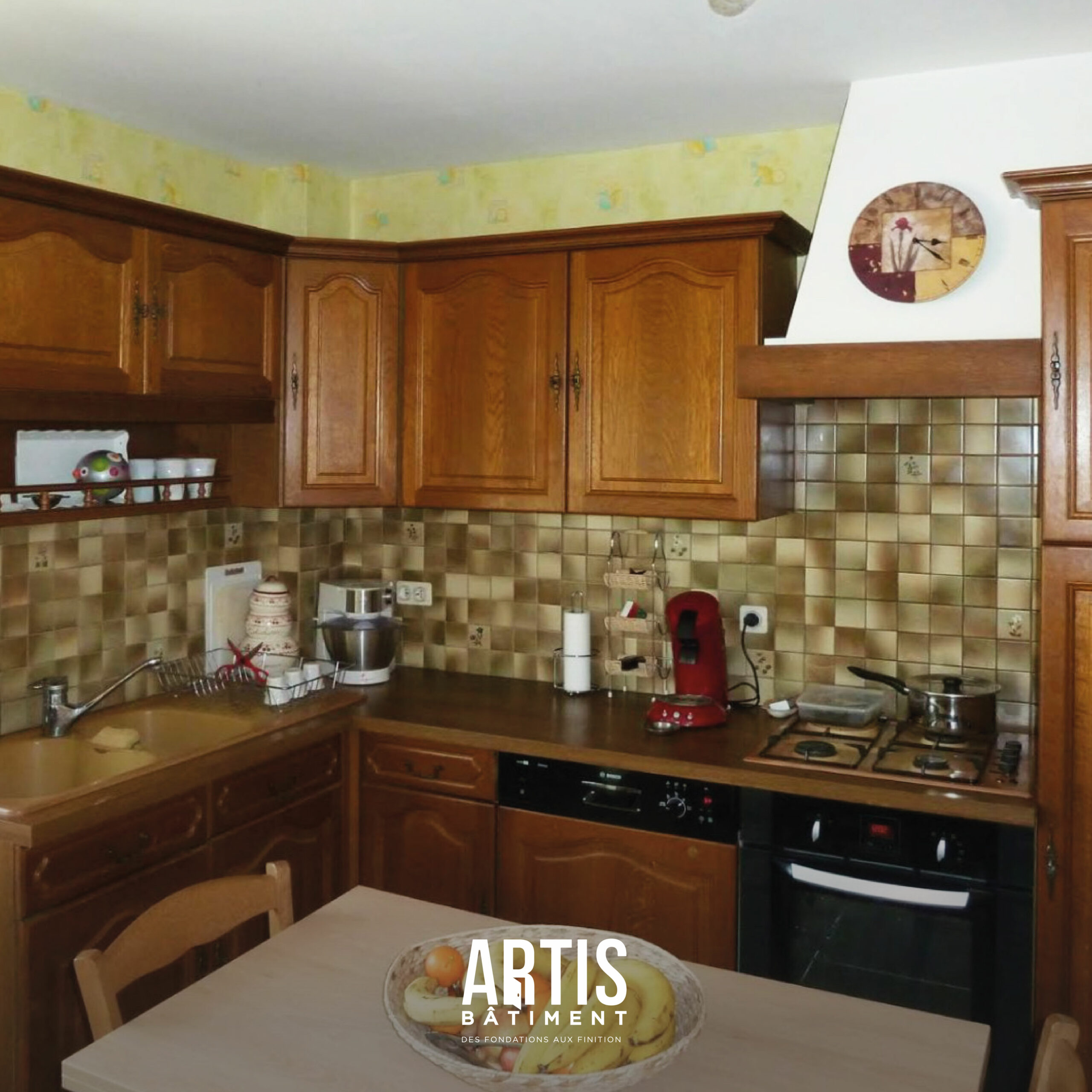 Ancienne cuisine en bois avec crédence carrelée avant rénovation complète de la pièce.