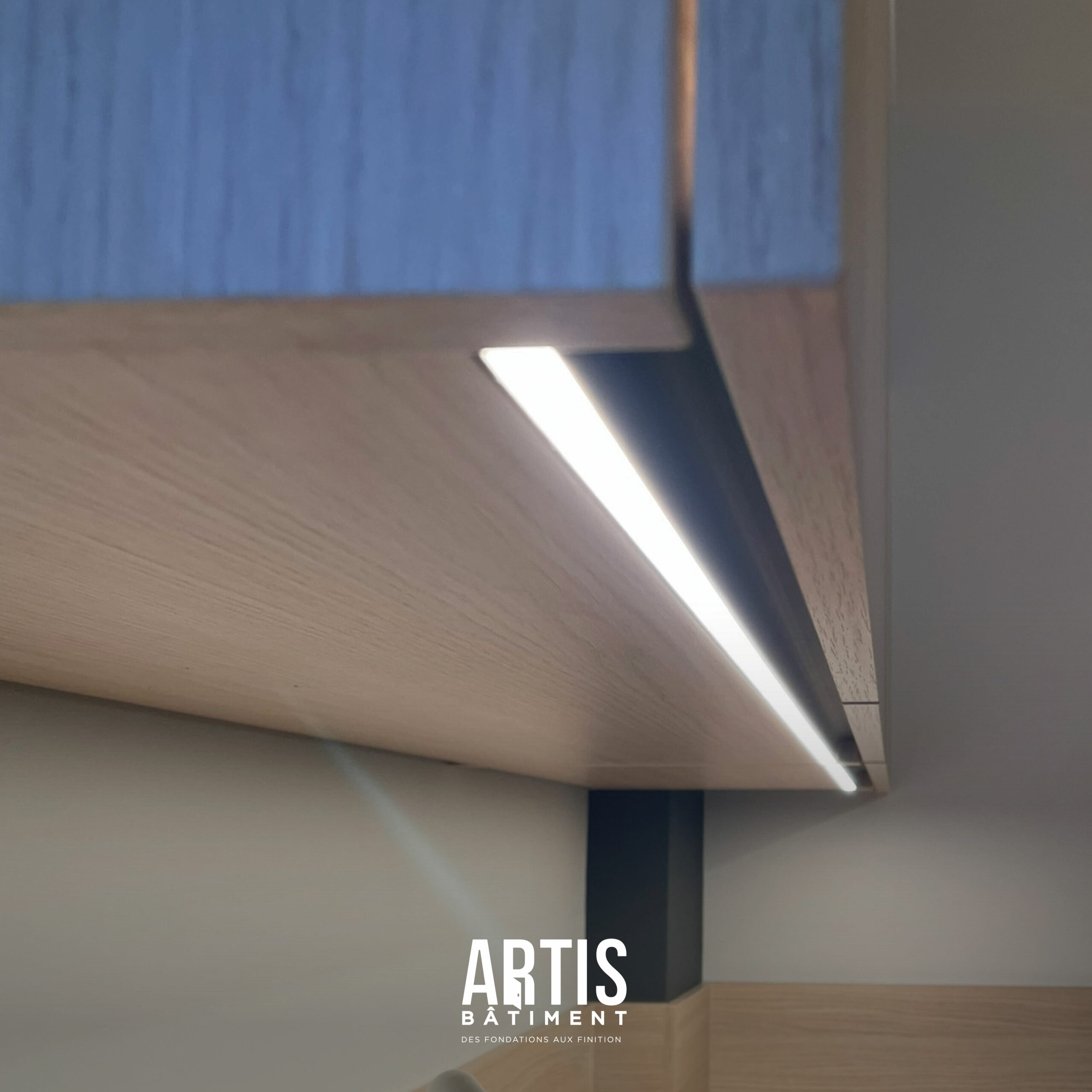 Bandeau LED intégré sous meuble dans une cuisine moderne avec plan de travail effet bois.