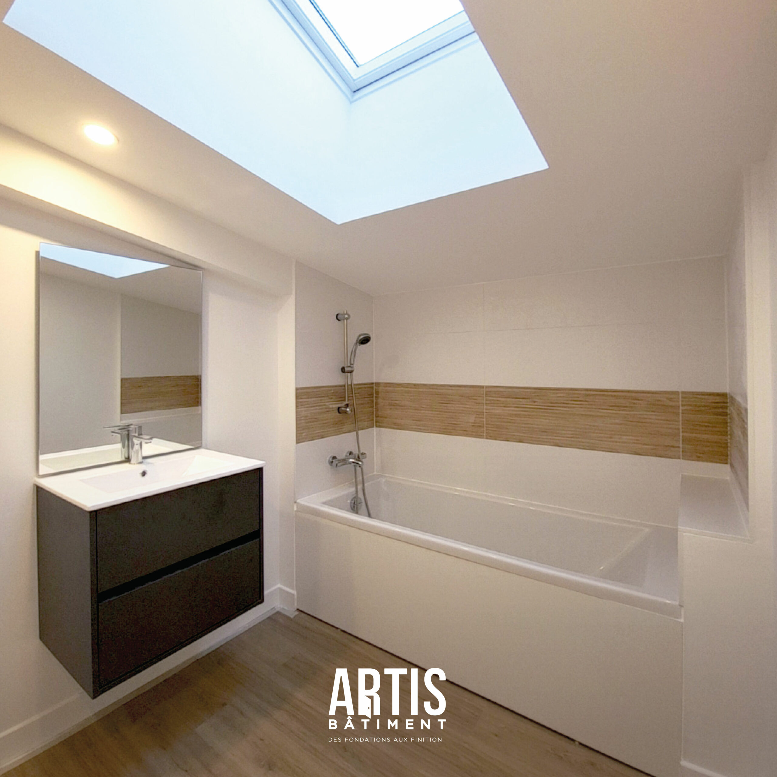 Baignoire intégrée dans une salle de bain rénovée avec carrelage moderne.