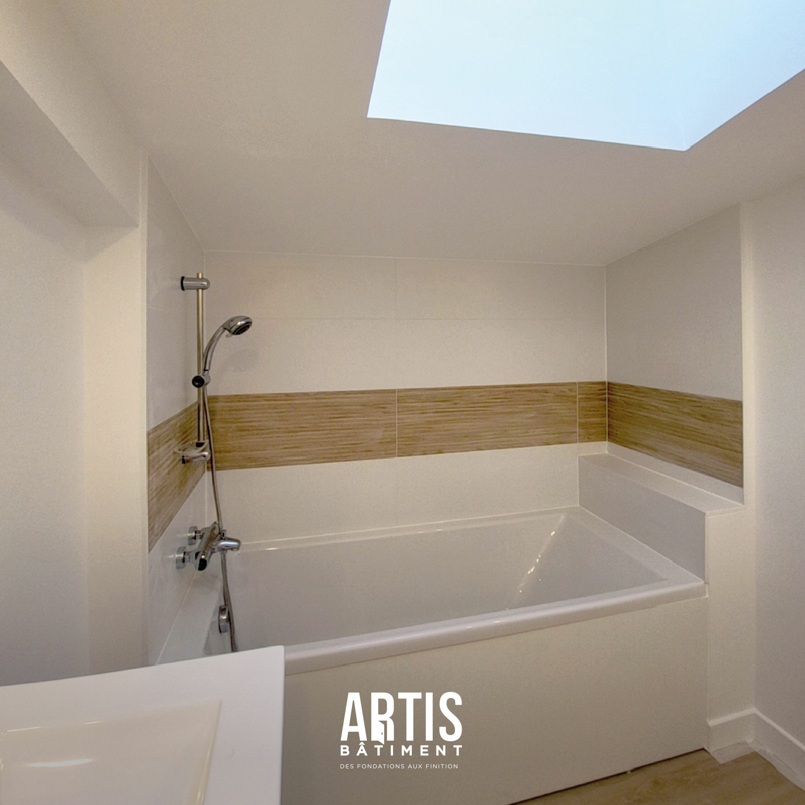 Détail carrelage salle de bain avec frise effet bois et baignoire.