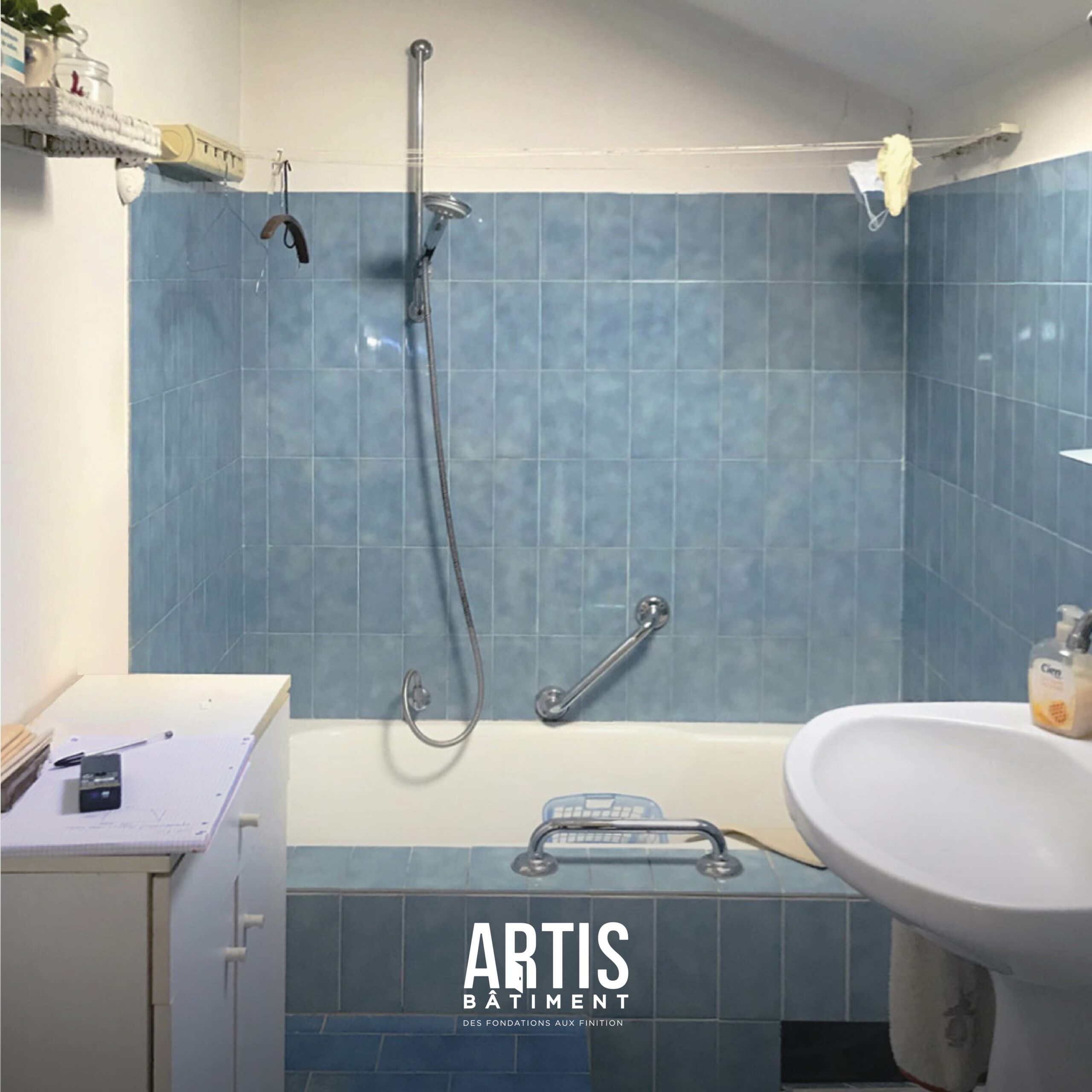 Ancienne salle de bain avec baignoire et carrelage bleu avant rénovation complète.