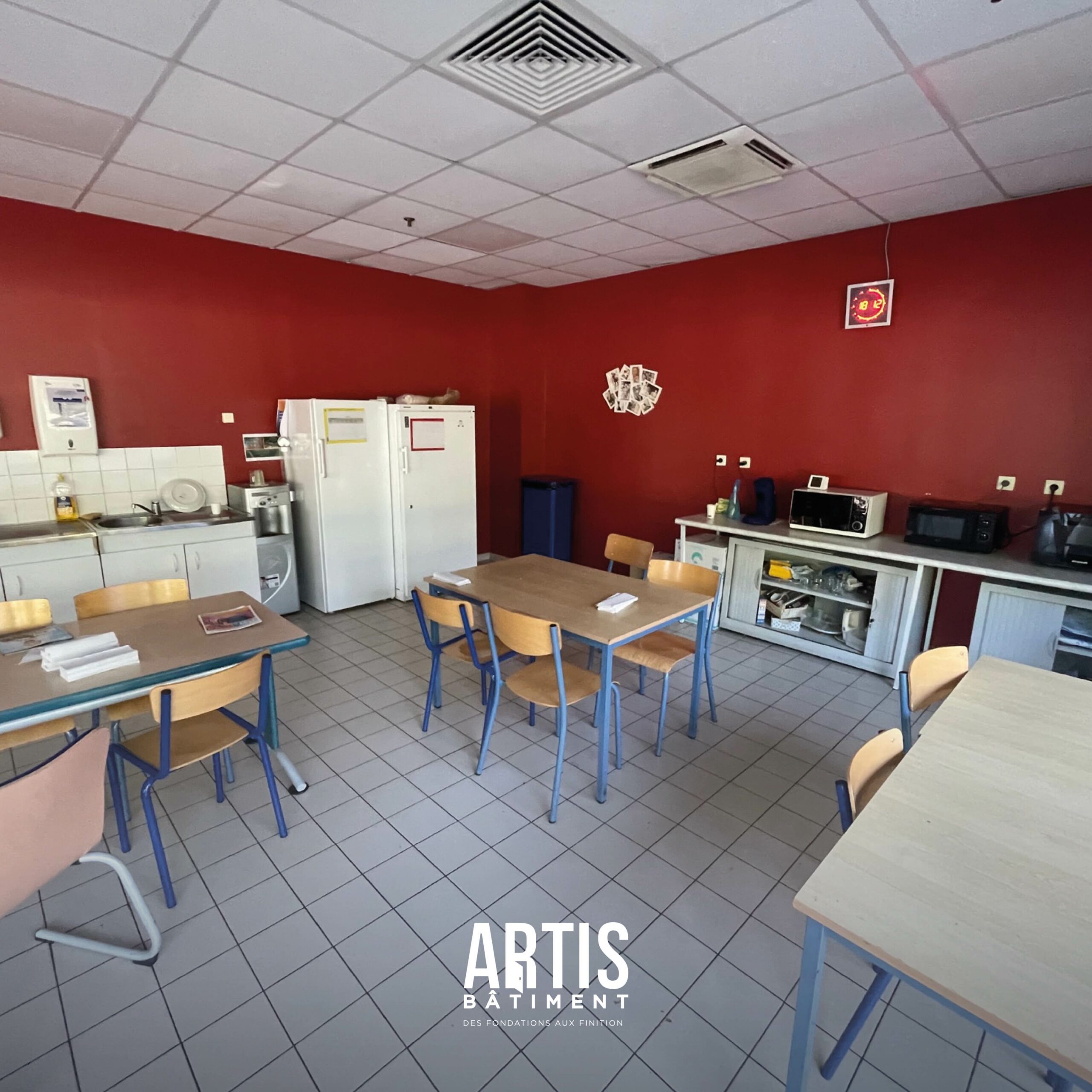 Ancienne salle de pause d’entreprise avec mobilier simple avant travaux de rénovation.