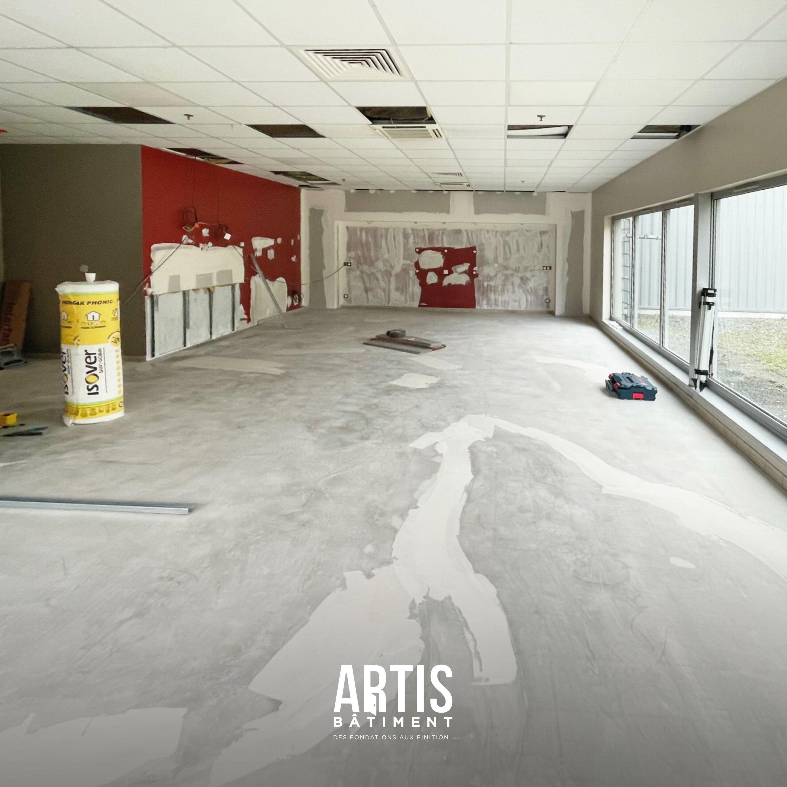 Salle de pause en cours de rénovation avec sols et murs en préparation avant aménagement.