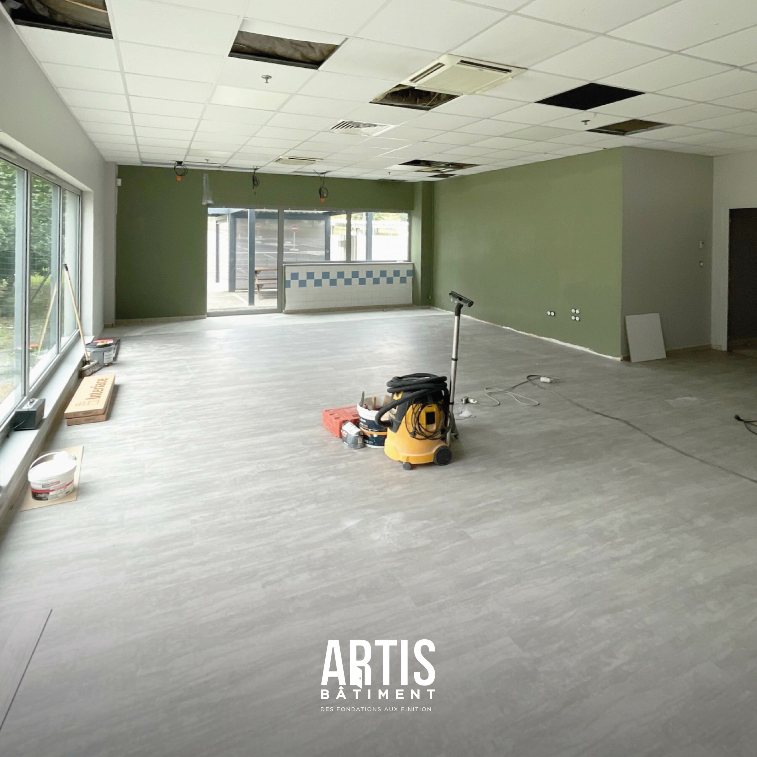 Travaux de rénovation d’un espace détente d’entreprise avec plafond technique et sol neuf.