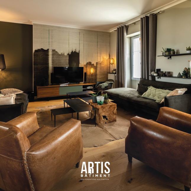 Salon rénové avec canapés, fauteuils en cuir, parquet bois et meuble TV design.