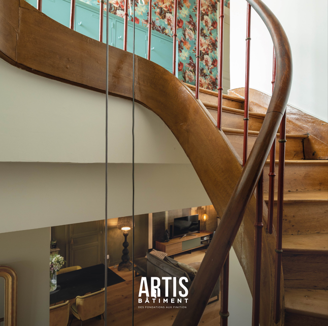Escalier ancien en bois rénové dans une maison de caractère avec garde-corps métallique.