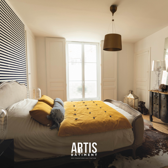 Chambre rénovée avec lit classique, parquet bois et décoration moderne.