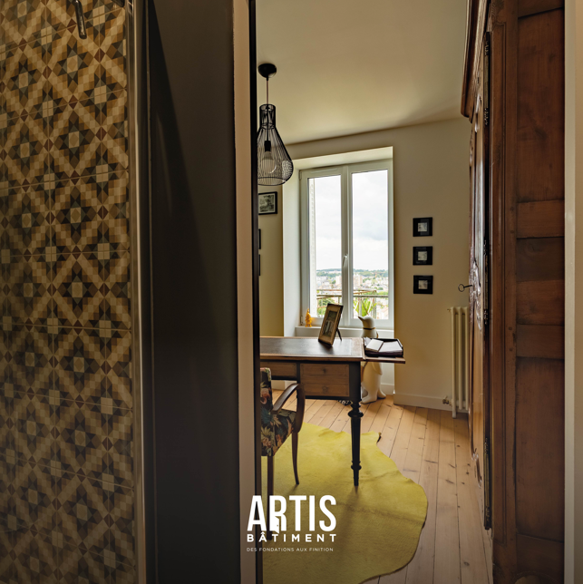 Bureau rénové dans une maison ancienne avec parquet bois et vue sur la ville.