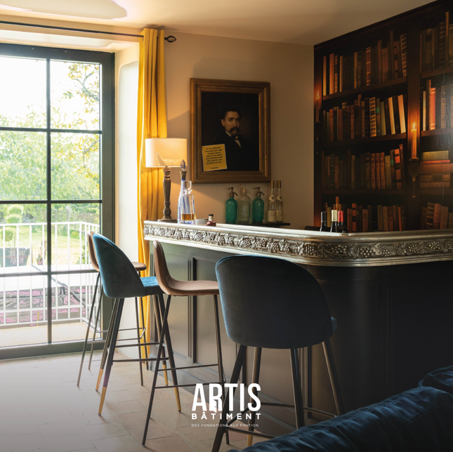 Coin bar avec comptoir et étagères style bibliothèque dans une maison rénovée.