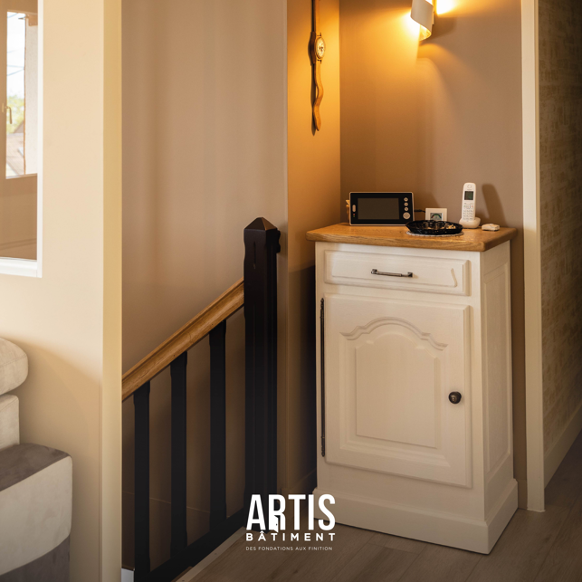 Petit meuble de rangement rénové avec façade blanche et plateau bois.