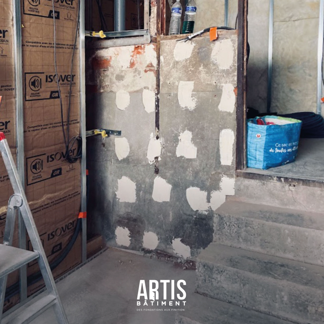 Cloison en plaques de plâtre avec réservations techniques en cours de finition sur chantier.