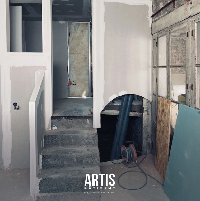 Escalier béton et cloison en placo en cours de rénovation intérieure.