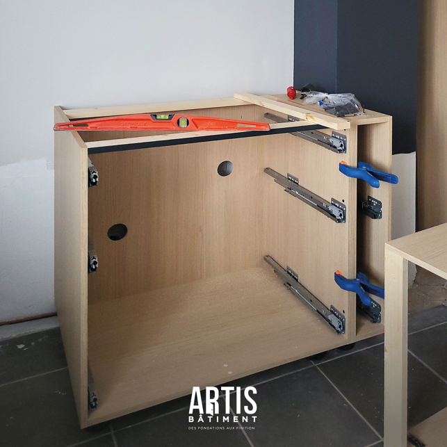 Montage et pose des meubles de cuisine en cours d’installation.