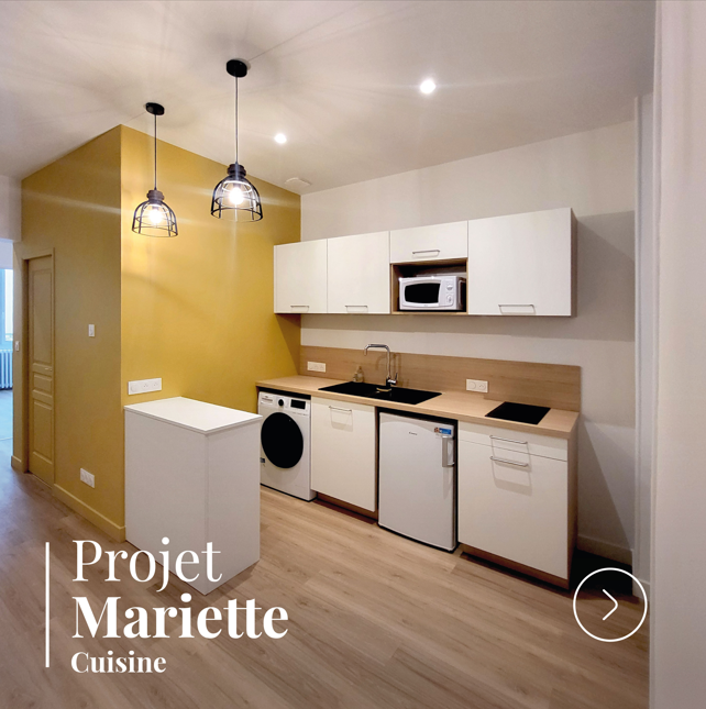 Cuisine rénovée et équipée avec meubles modernes, plan de travail bois et mur coloré au Mans.