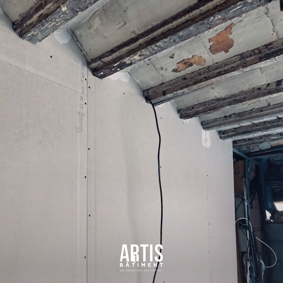 Reprise des murs sous un plafond voûté ancien pendant la rénovation