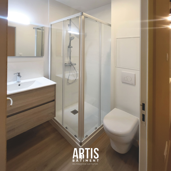 Salle d’eau rénovée avec douche, meuble vasque et toilettes suspendues